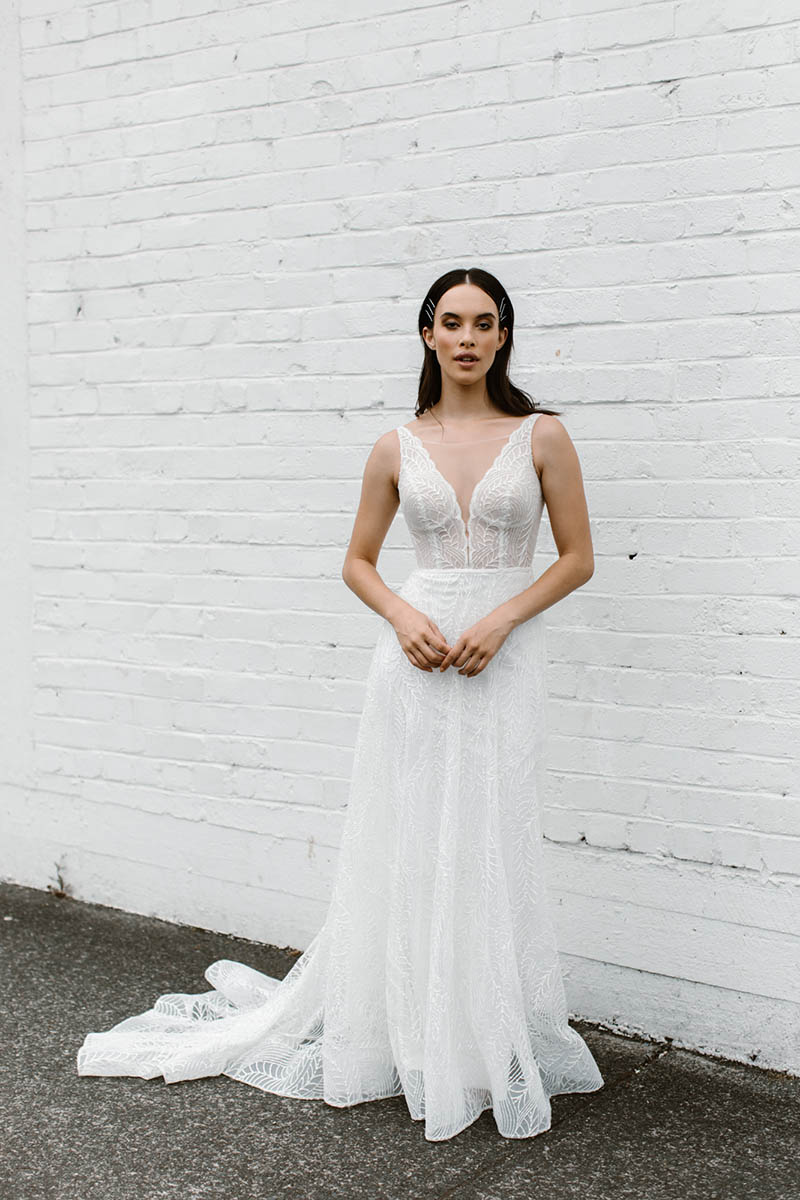 The deep V-neckline & illusion bodice of this A-line wedding dress accentuates the natural waistline & flows down into a stunning rounded train.