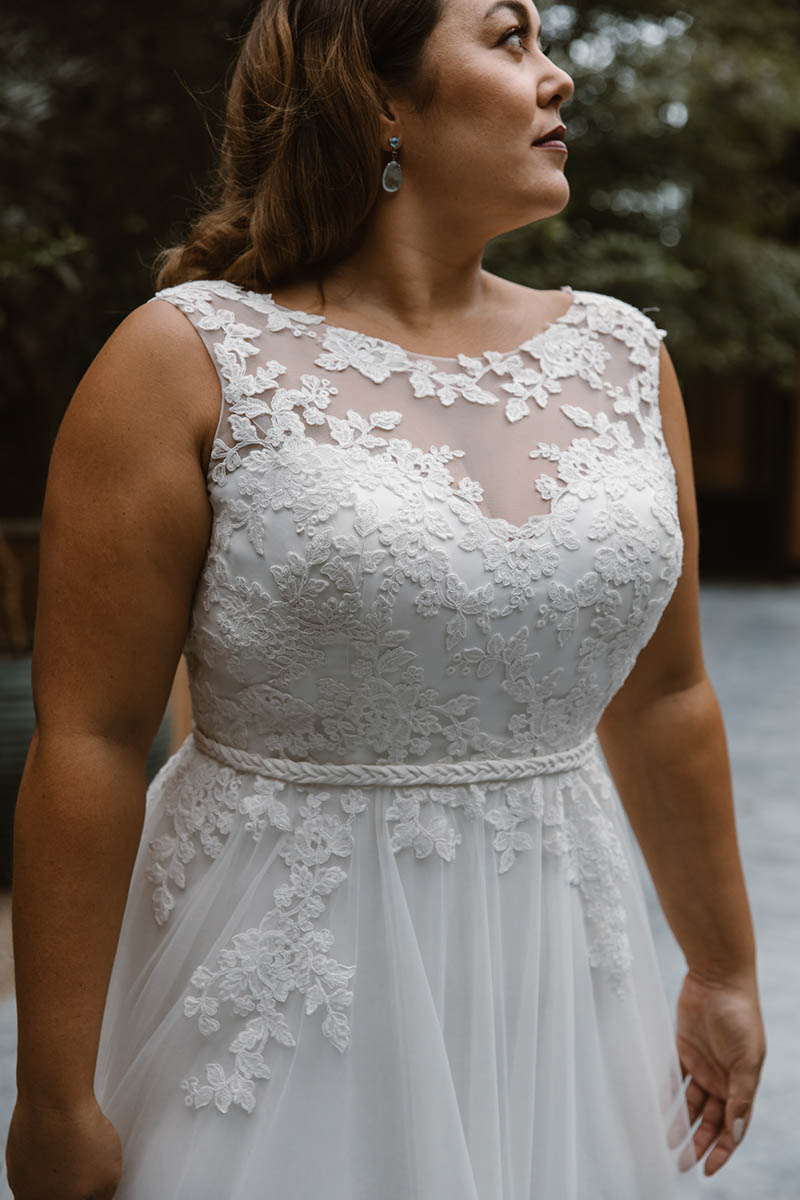In this stunning A-line wedding gown rich lace appliques adorn the sheer bateau neckline & cascade elegantly down the bodice and over the natural waistline.