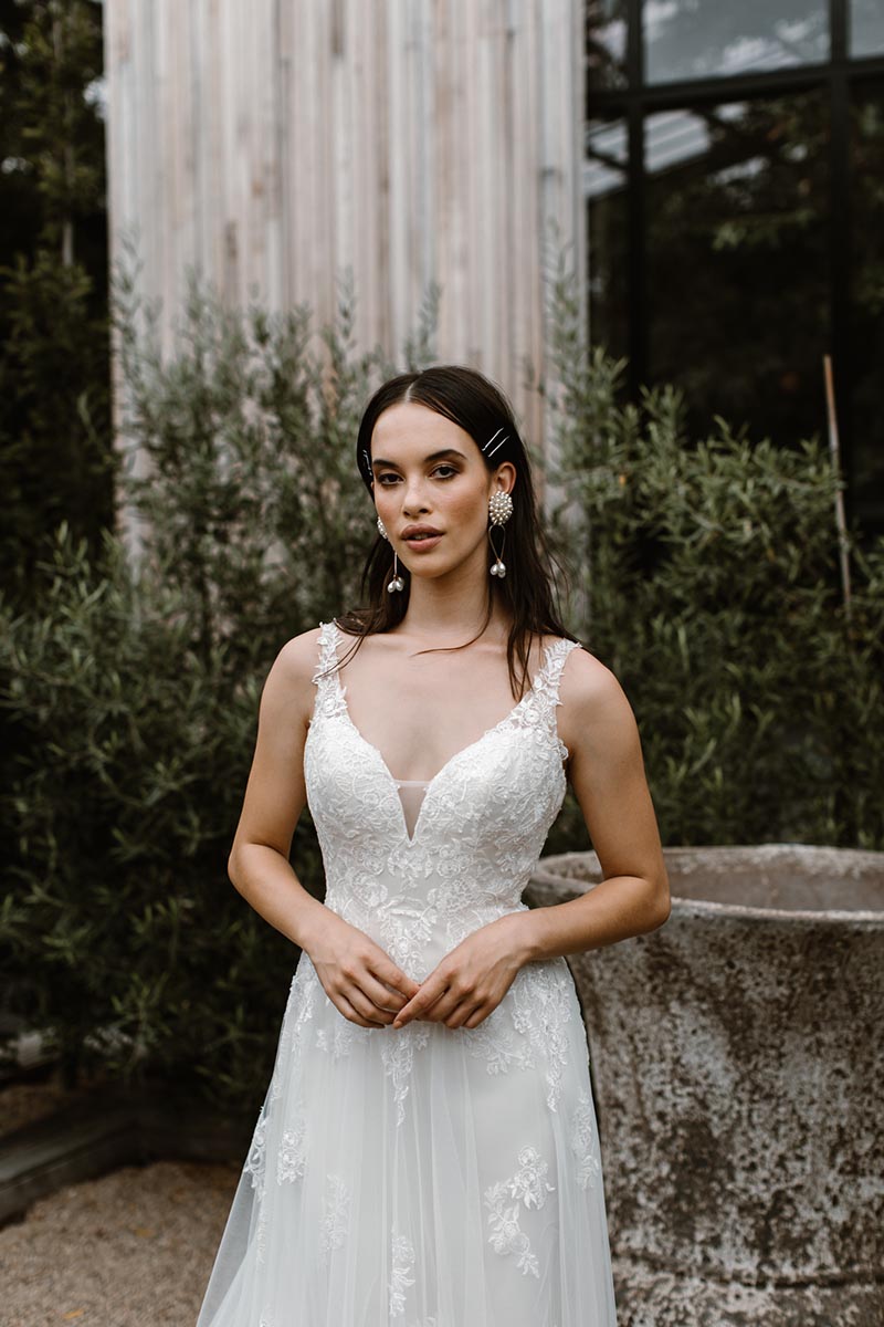 A young and fresh twist on traditional, this wedding dress is a perfect mix of floral laces and soft tulle that flows down into a faltering A-line skirt.